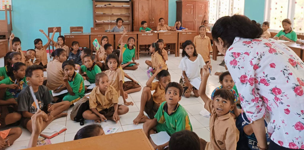 Volunteer interacting with students in a school classroom