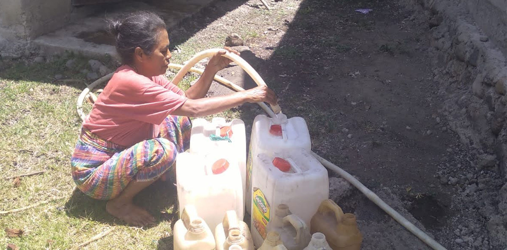 a lady collecting water in a can