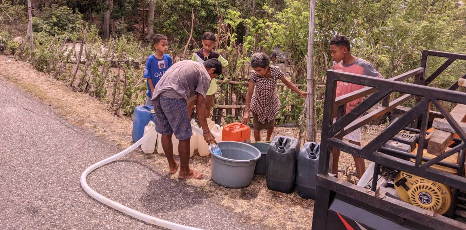 villagers collecting water in drums and cans