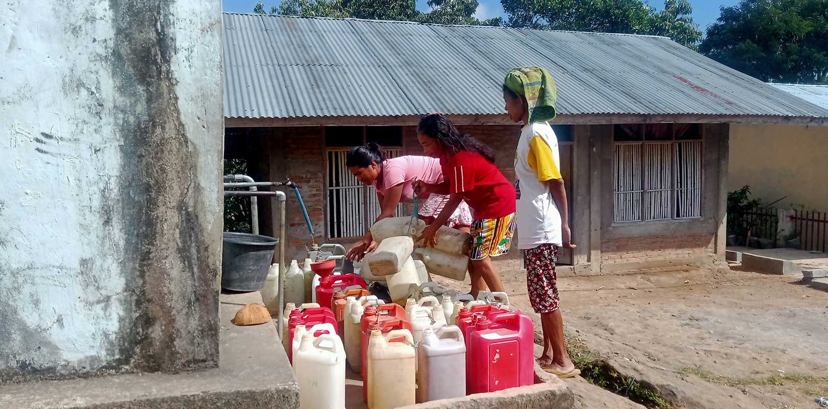 Girls collecting water in cans