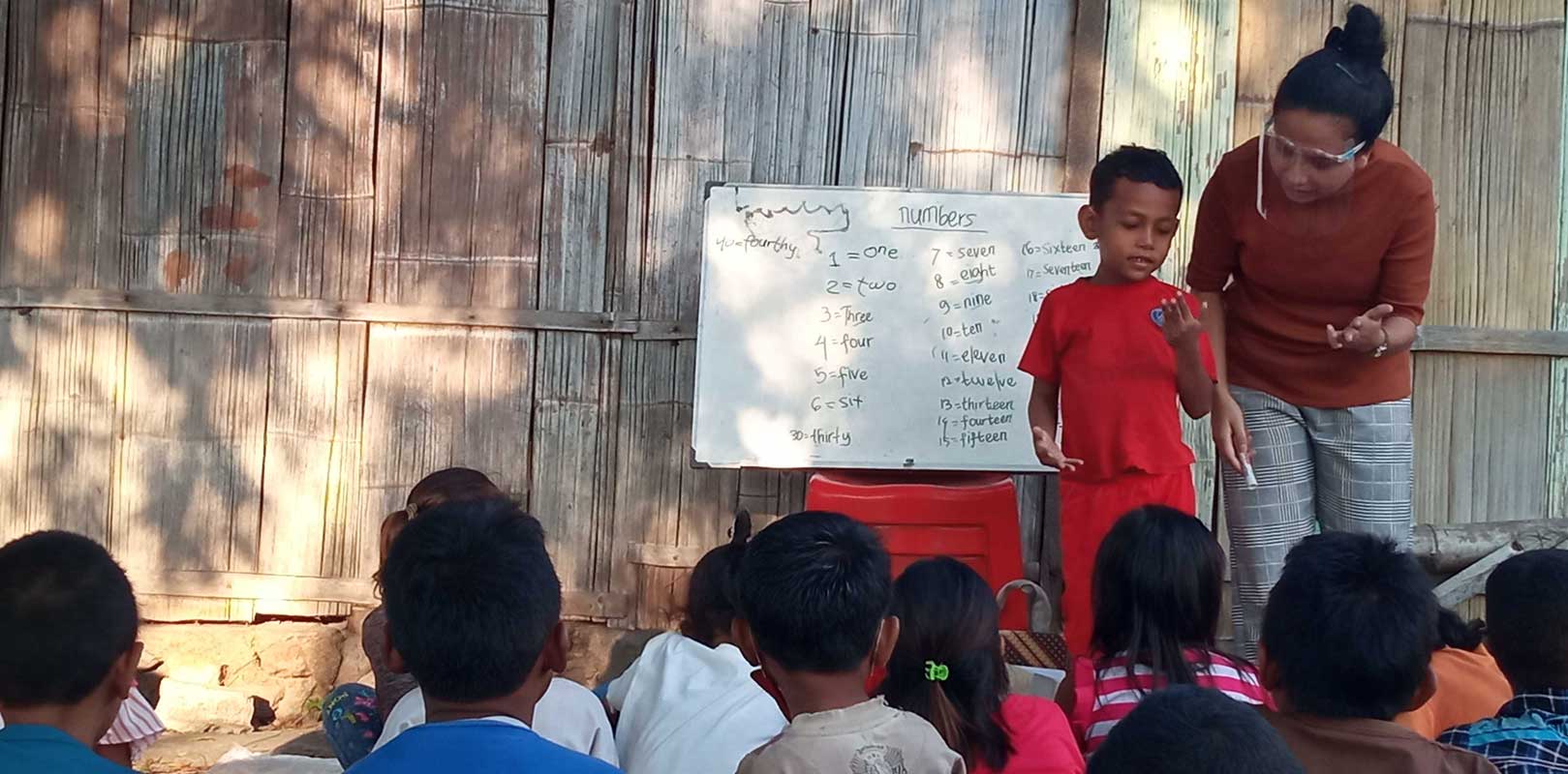 a volunteer interacting with students in english club