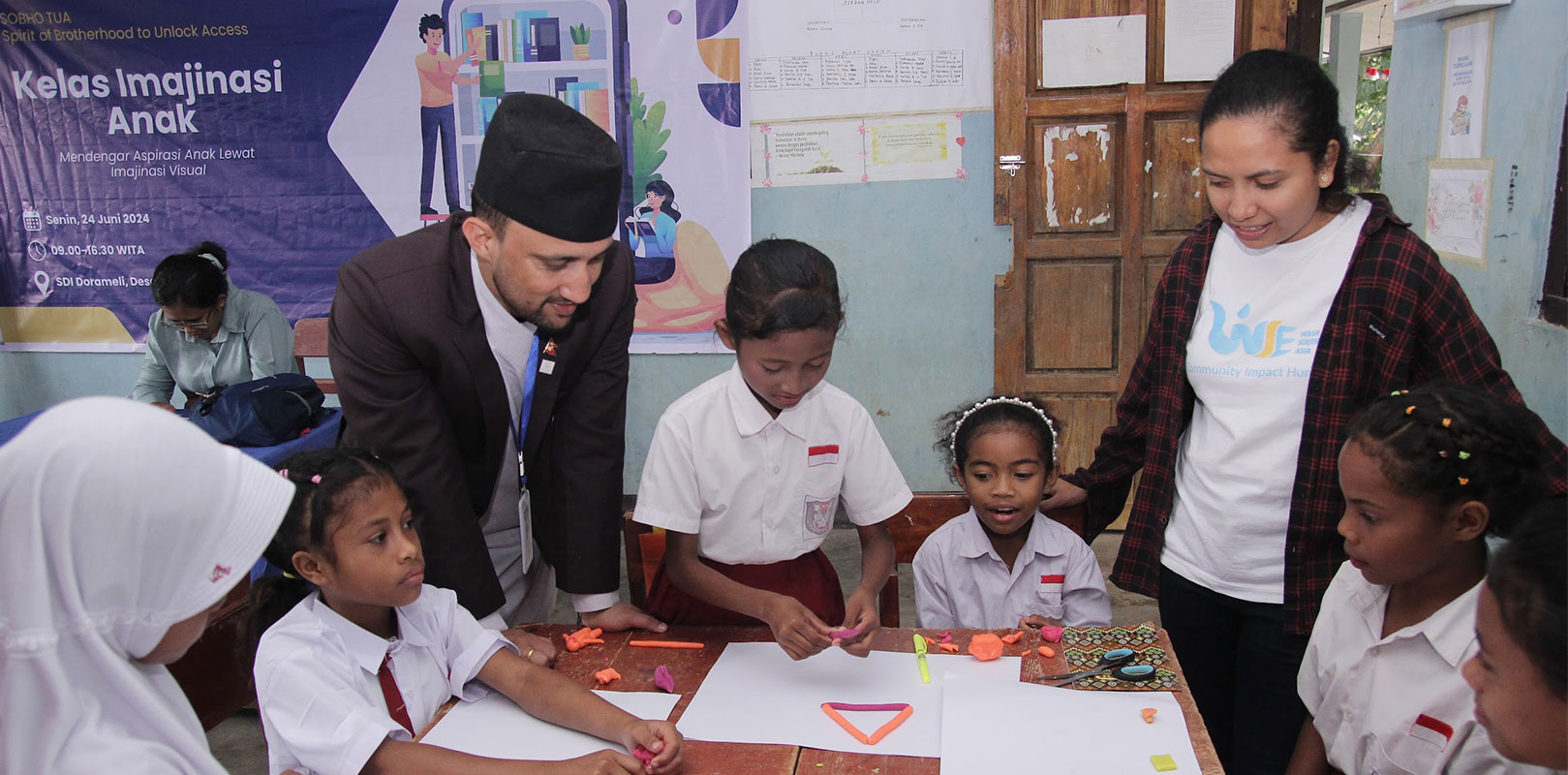 volunteer interacting with staff and students in a school as part of workshop to integrate technology into schools