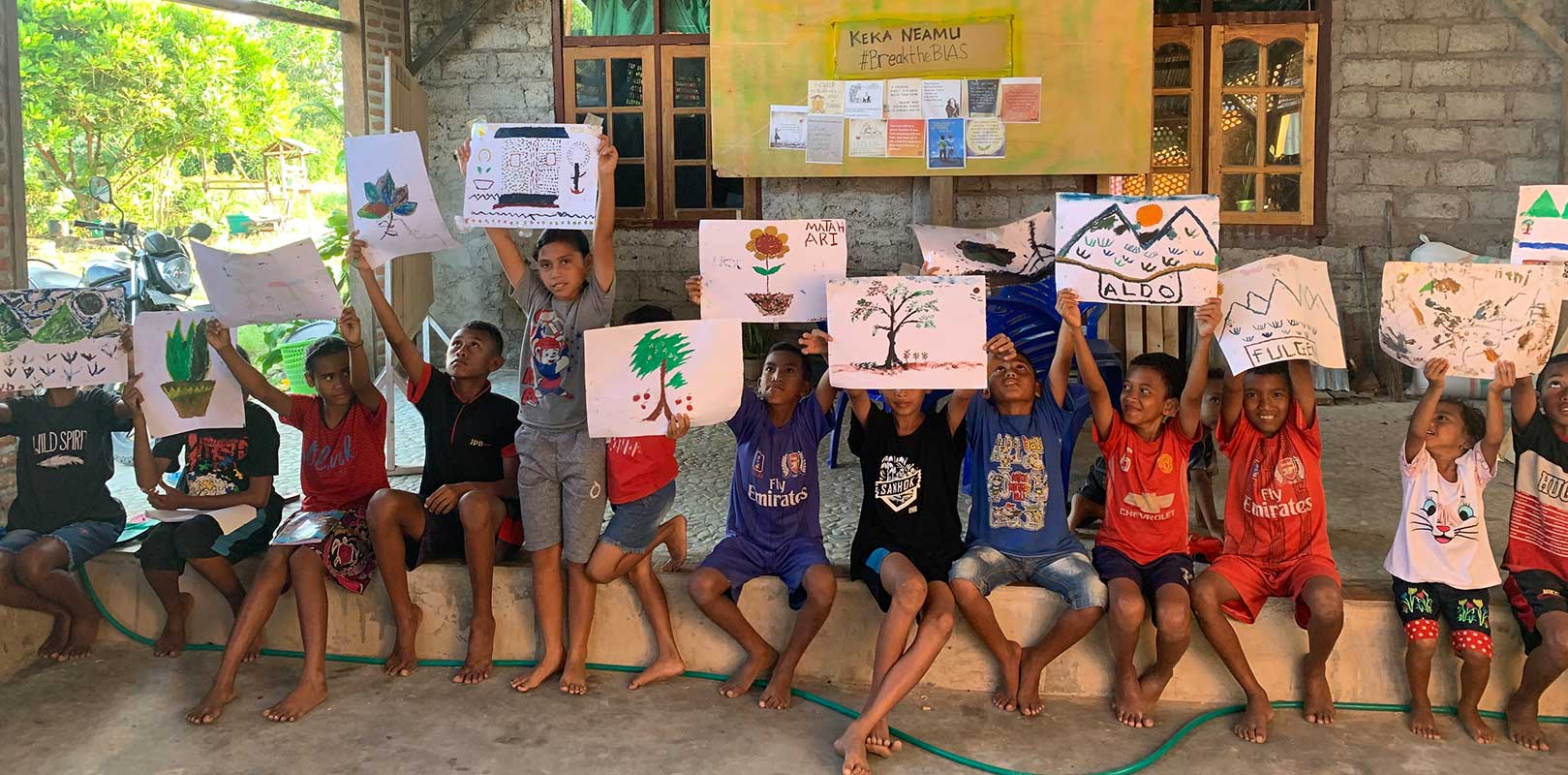 students posing for a photo with their artwork at Keka Neamu Kids Group
