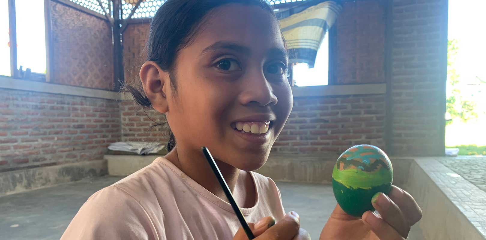 a student posing with a painted egg