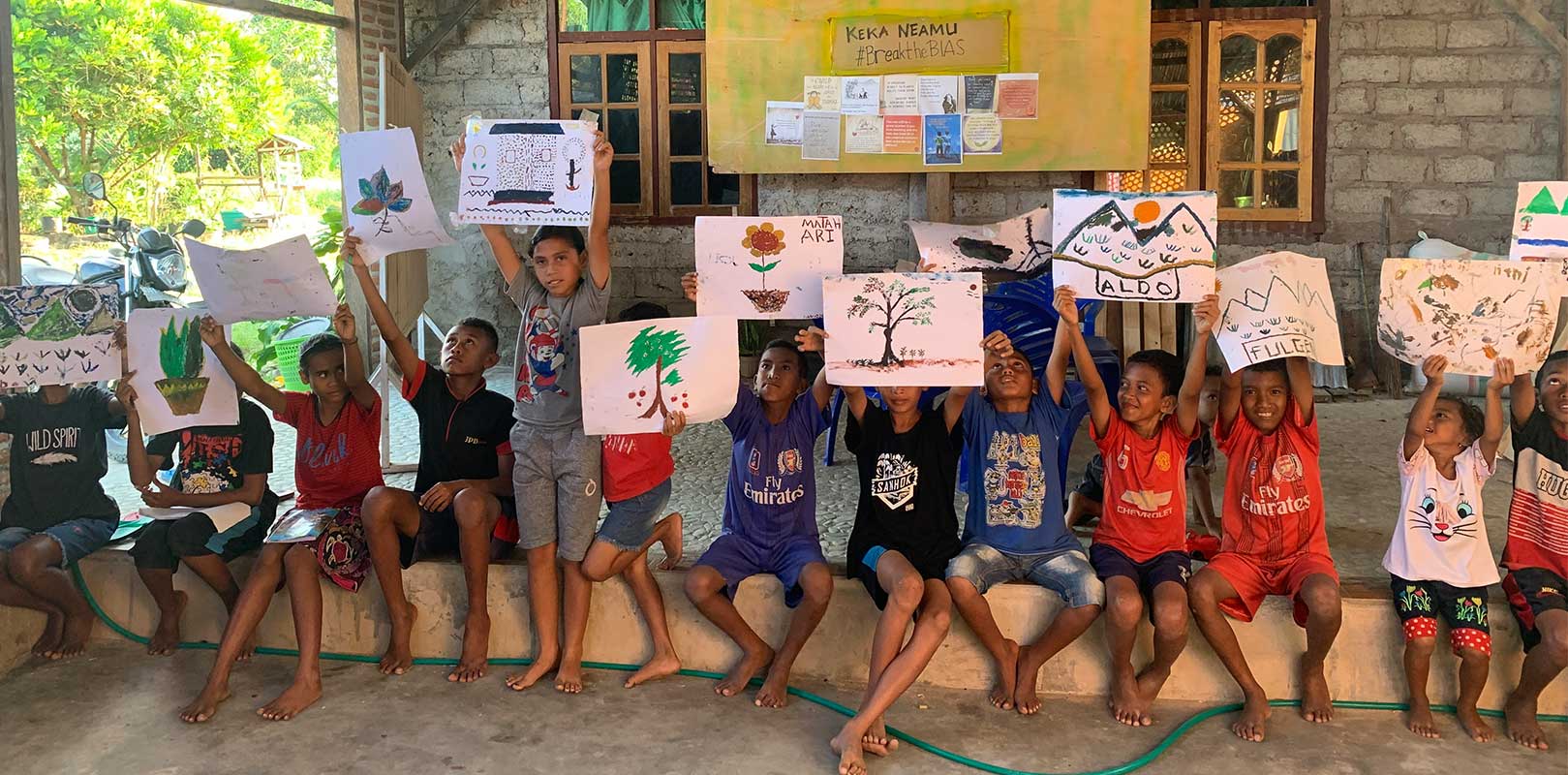 students posing for a photo with their artwork at Keka Neamu Kids Group
