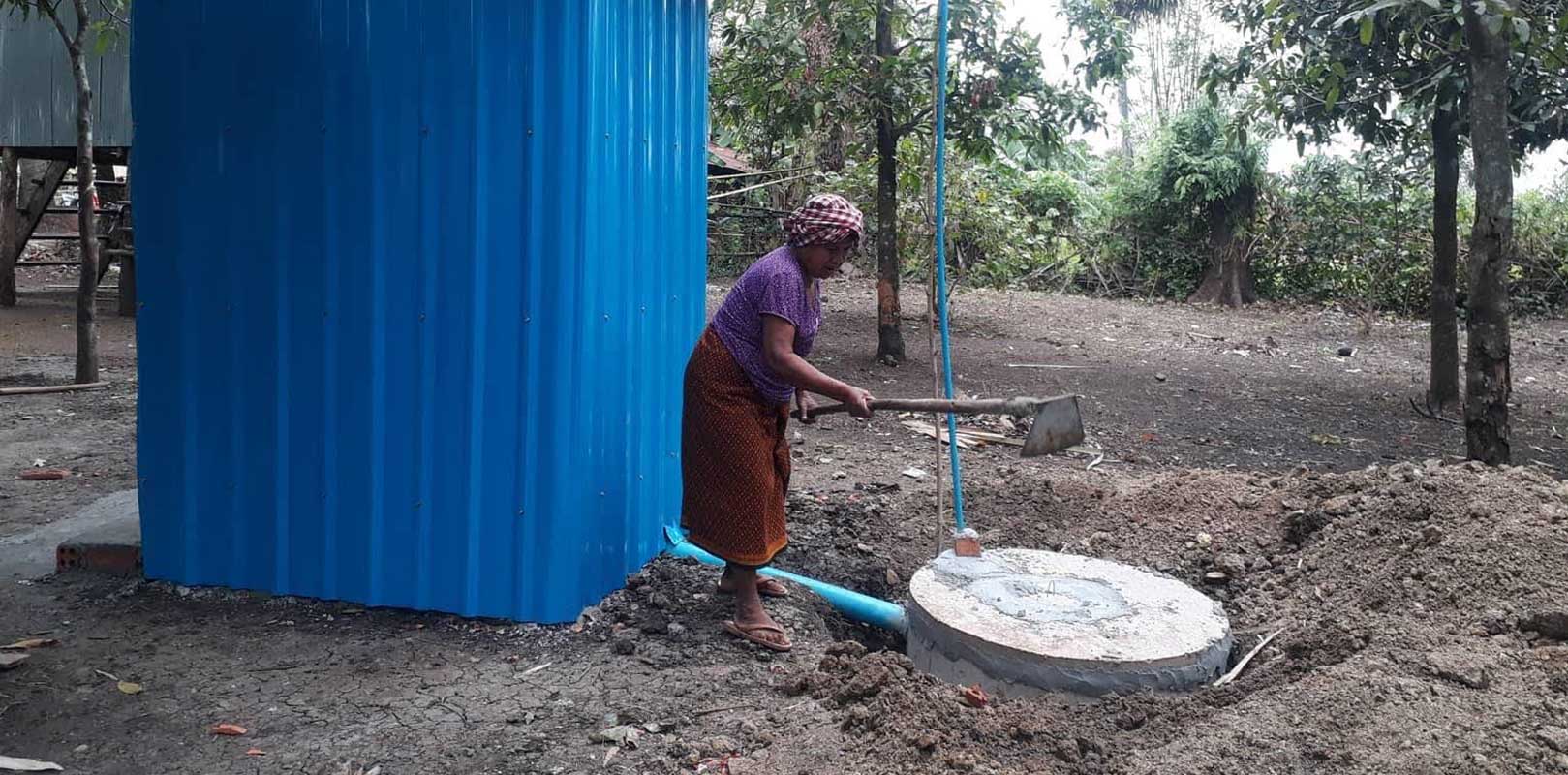 finished toilet with a worker still working on it