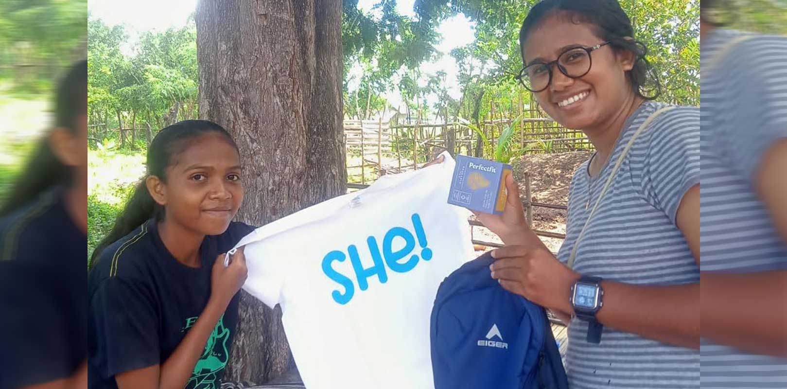 A volunteer giving a kit to a girl
