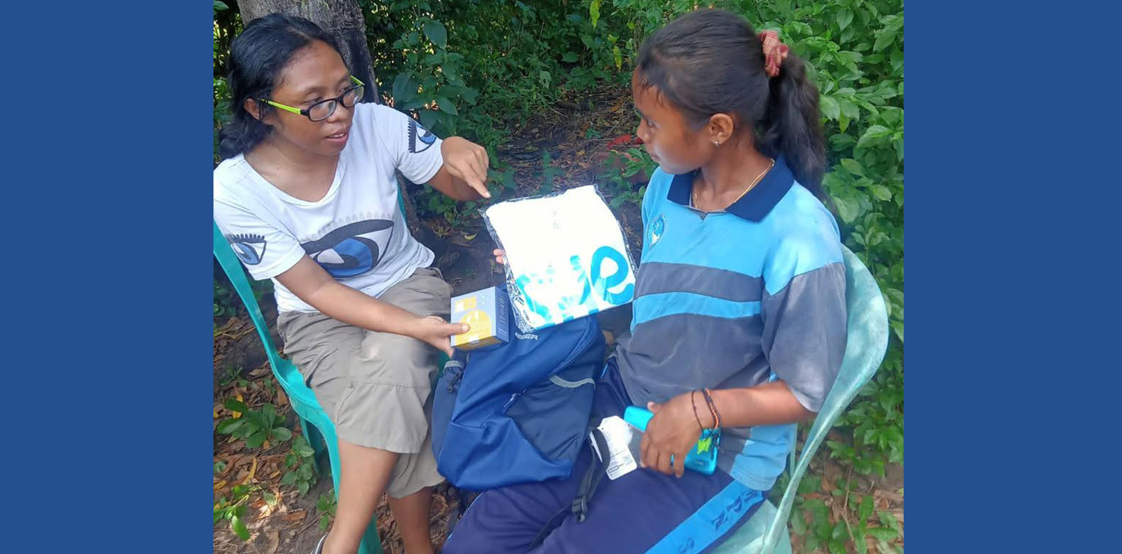 A volunteer giving a kit to a girl
