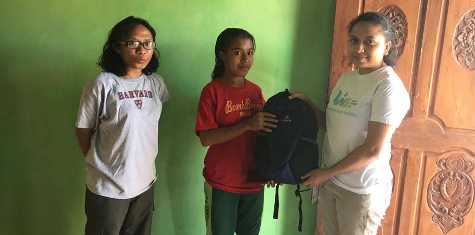 A volunteer giving a kit to a girl
