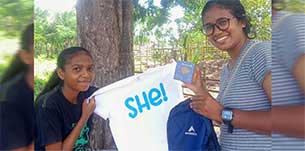 a photo of a volunteer giving kit related to reproductive health to a student