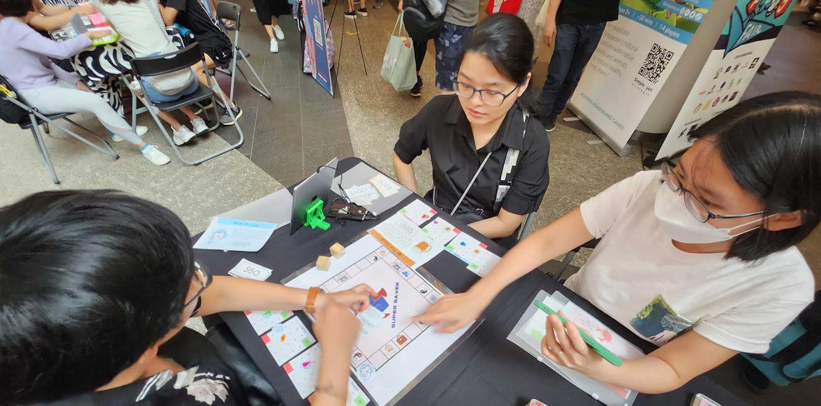 participants playing the board game, super saver